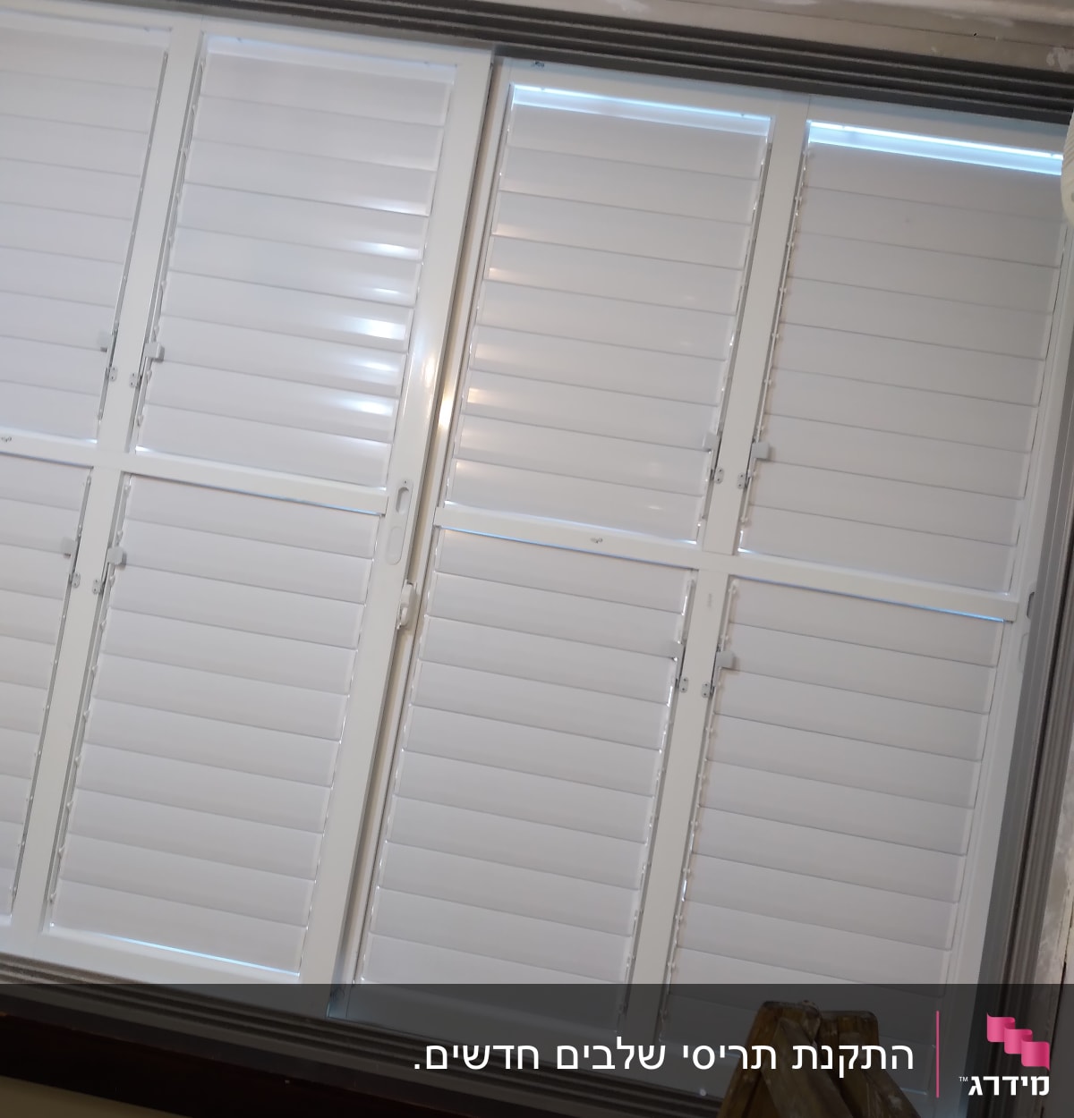 תריסים לבנים סגורים עם מסגרת מתכת